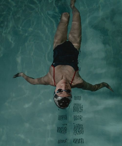 Woman performing a fluid motion exercise in a calm setting.